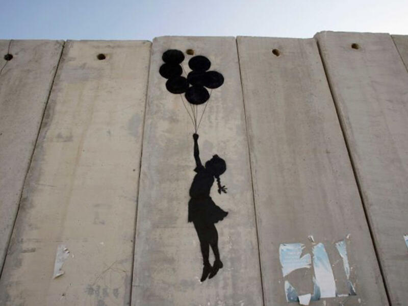 Visitors to his website are reminded that Israel’s 425-mile-long West Bank barrier, which separates Israel from Palestine is considered illegal by the United Nations. Banksy says the wall is "the ultimate activity holiday destination for graffiti writers.” Up, up and away!