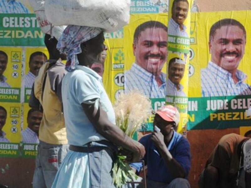 A Haitian woman passes in front of presidential candidate Jude Celestin posters in Petion-Ville. Deadly violence rocked the run-up to Haiti elections and protests simmered over the handling of a raging cholera outbreak, feeding fears Tuesday that the nation could slip toward broader unrest