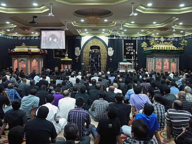 Ashura, aside from the general sombre tone to the day, is actively made up of mourning rituals and passion plays re-enacting
the historical martyrdom and suffering. While centered in the more widely recognized, high profile outdoor parades, there is also
activity in indoor congregation halls known as Hussainia (pictured).