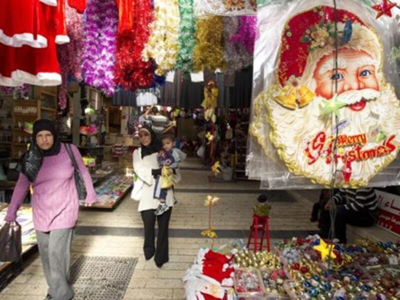 Arab-Israeli women walk past stalls selling Christmas decorations at a market in the Arab-Israeli town of Nazareth.