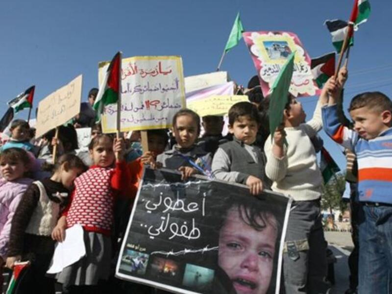 Palestinian children take part in a protest to mark the second anniversary of Israel's three-week offensive, in which over 1000 people were killed, in Jabalia refugee camp, in northern Gaza.