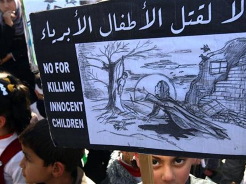 No for killing innocent children sign, held by Palestinian children who took a part in protesting against the invasion of Gaza two years ago.