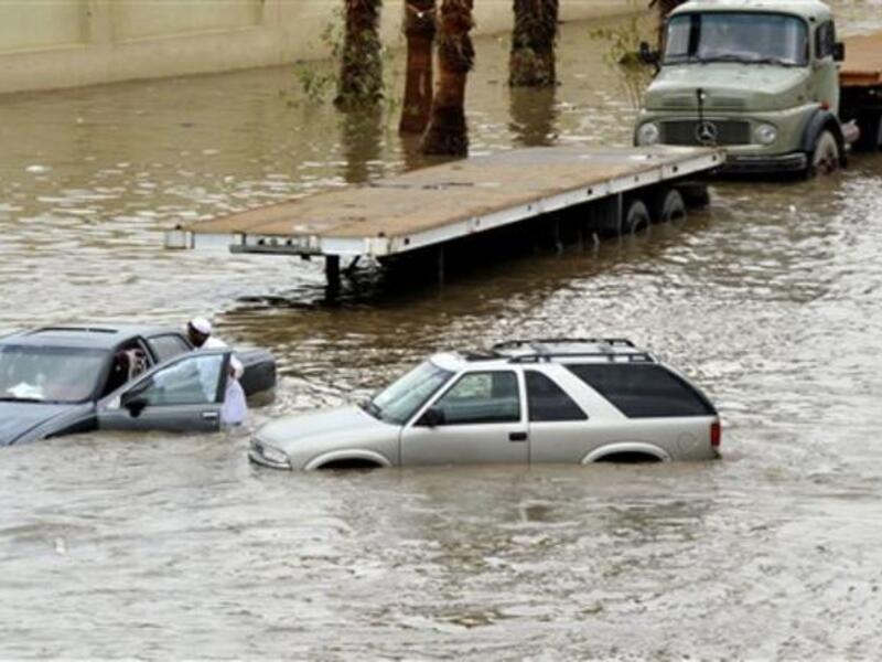 Saudis leave their vehicles in a flooded street following heavy rain in the Red Sea port city of Jeddah.