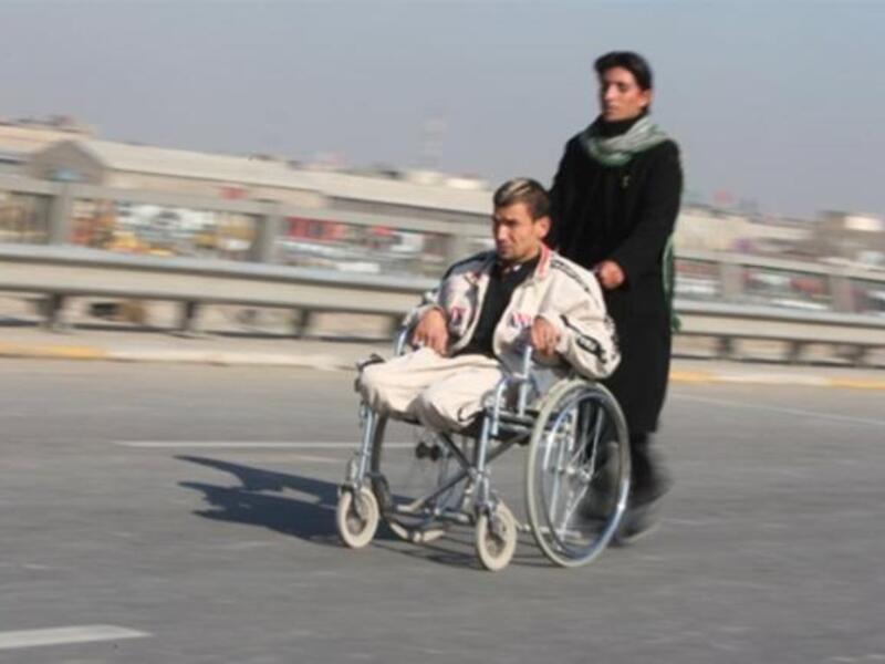 A handicapped Shiite pilgrim is pushed on a wheelchair on a highway linking Baghdad to Karbala, 120 kms south of the capital.