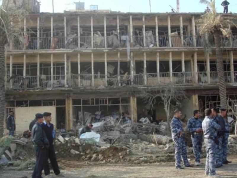 Members of Iraqi security forces gather next to the ruins of the Baquba headquarters of the Force Protection Service (FPS), where a suicide bomber rammed an ambulance packed with explosives killing 13 people.