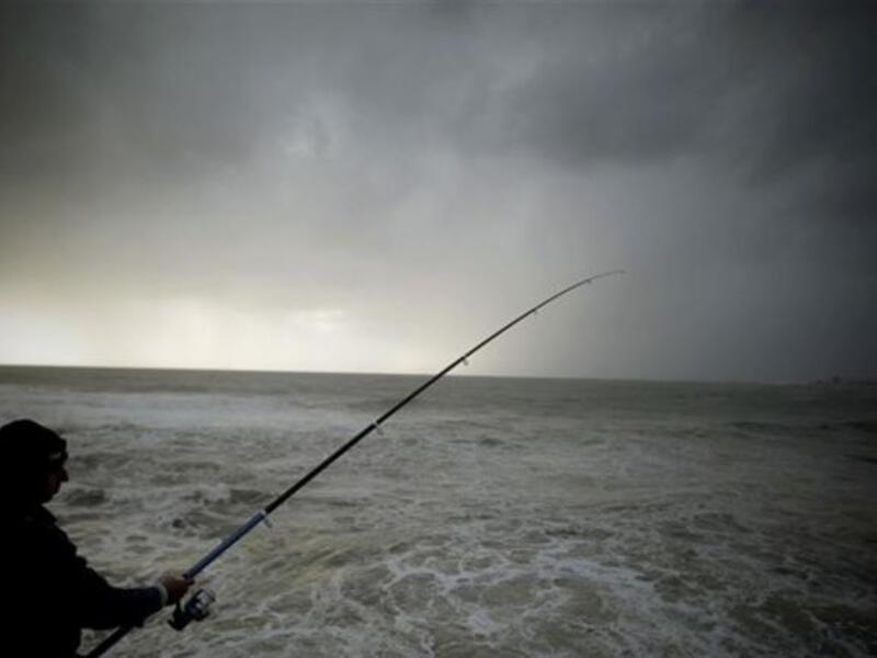  A Lebanese man fishes during a storm on the Mediterranean coast off the northern Lebanese port of Byblos.