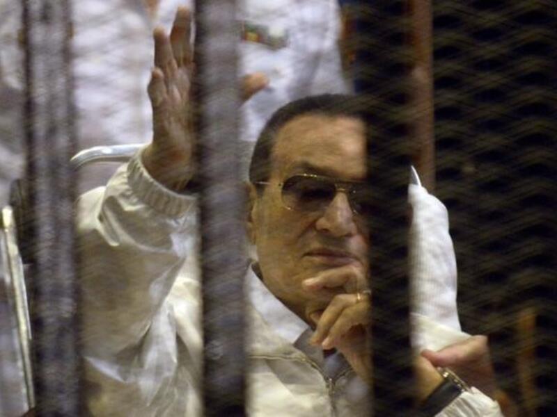 Hosni Mubarak waves from his bed during his retrial which was quickly adjourned (AFP)