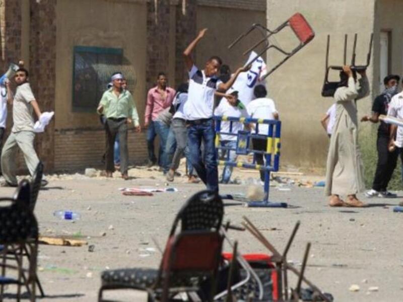 An Egyptian supporter of the former Egyptian president throws a chair as clashes erupted between loyalists and foes of Egypt's former president who is being tried on murder charges.