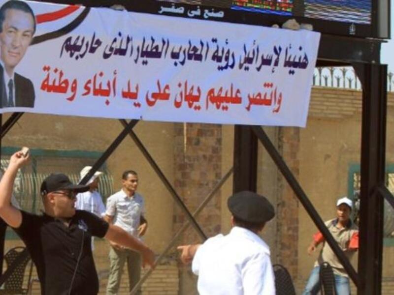 Egyptian supporters of former president Hosni Mubarak (banner) throws a stone as clashes erupted between loyalists and foes of Egypt's former president Hosni Mubarak .