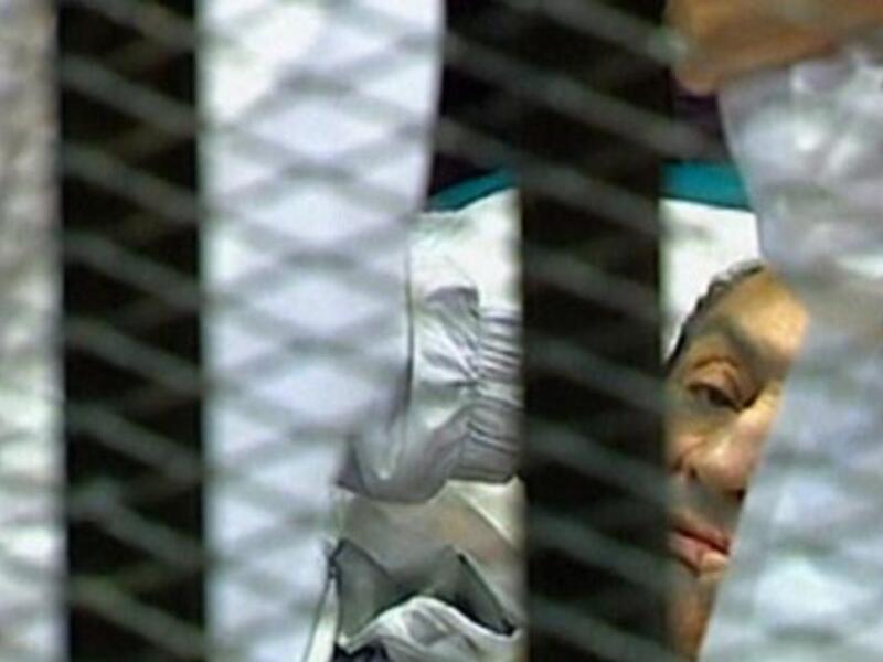 Egyptian former president Hosni Mubarak 'lying' hemmed into his 'cage' in a holding cell in the court room at the Cairo Criminal Court where he faces murder charges, is the first Arab ruler to appear in court in person in a historic moment for a region whose leaders are rarely held to account. 