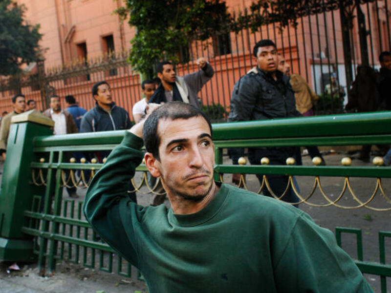 Anti-Mubarak protesters throws rocks at pro-government supporters during a clash between pro - and anti - Mubarak protesters.
