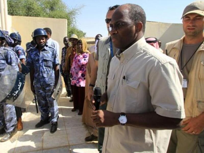 Djibril Bassole, chief negotiator for the UN and the African Union, is surrounded by bodyguards and Sudanese policemen as he prepares to address students protesting outside the University of Zalingei.