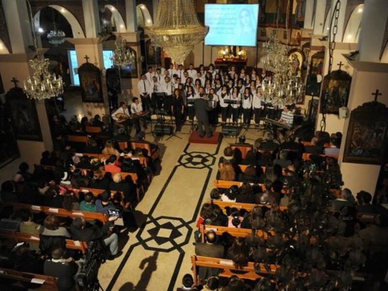 Syria christmas celebrations include choirs singing to a burning backdrop.