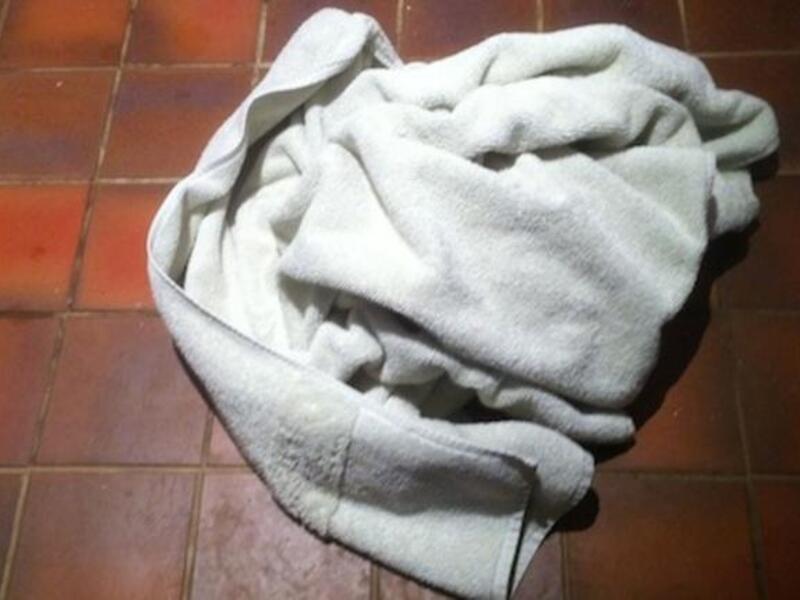 Towels piled on floor outside hotel room