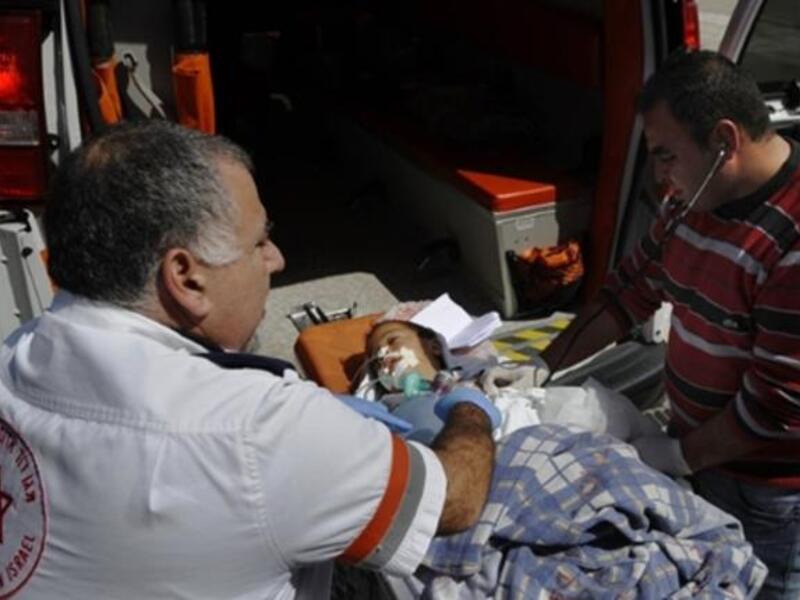 Israeli and Palestinian paramedics treat a wounded Palestinian boy being transfered for medical treatment to an Israeli hospital after he was injured in an Israeli army attack on the Palestinian Gaza Strip.