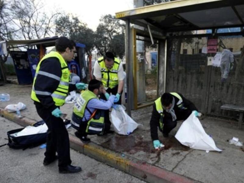 Israeli volunteers from the Zaka organization clean the blood stains and collect human remains at the scene of an explosion near Jerusalem's central bus station.