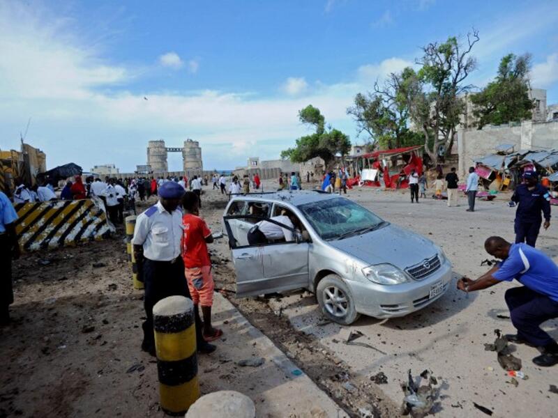Somali security forces personnel and police secure the area at the scene of a car bomb explosion in Mogadishu, Somalia on May 9, 2016. (AFP/Mohamed Abdiwahab)