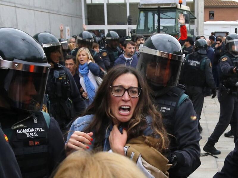 Spanish Guardia Civil guards clash with voters outside a polling station in Sant Julia de Ramis, in the Catalonia region (Raymond Roig/AFP)