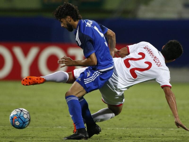 UAE's Al-Nasr club player Tariq Ahmed (L) tries to control the ball as Uzbekistan's Lokomotiv club player Sanjar Shaakhmedov falls to the ground during their Asian Champions League (AFC) group A football match at the Rashid Al-Maktoum Stadium in Dubai on April 20, 2016.
KARIM SAHIB / AFP