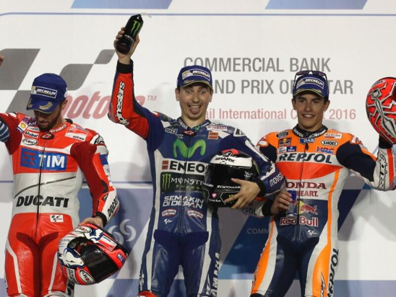 Spanish MotoGP rider Jorge Lorenzo (C) of the Movistar Yamaha MotoGP team celebrates on the podium after winning the Qatar MotoGP race with Italian rider Andrea Dovizioso (L) of the Ducati Team who won second place and Spanish rider Marc Marquez (R) third place at the Losail International Circuit in Doha on March 20, 2016.
KARIM JAAFAR / AFP