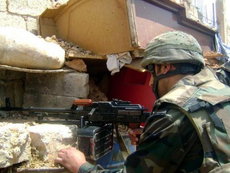 A handout picture released by the Syrian Arab News Agency (SANA) on May 20, 2013, allegedly shows a Syrian soldier scanning the area for hostiles in the the town of Qusayr in Homs province (SANA / AFP)