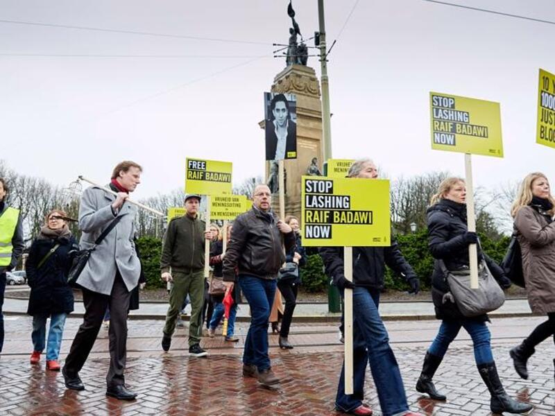 Demonstrators from Amnesty International, a human rights watchdog, protest flogging of jailed Saudi blogger Raif Badawi in front of the Saudi embassy in the Hague.  (AFP/File)