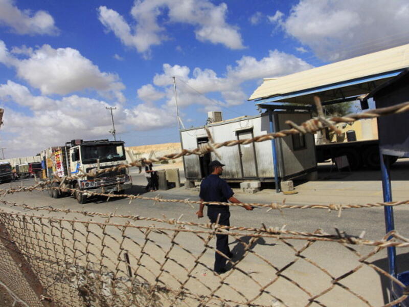 Trucks cross into Rafah town through the Kerem Shalom crossing between Israel and the southern Gaza Strip. [Said Khatib/AFP]