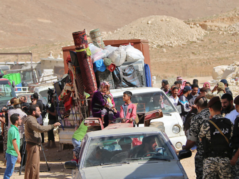 Lebanese security forces check identity and papers of Syrian refugees getting ready to cross into Syria from the eastern Lebanese border town of Arsal, Lebanon. (AFP)