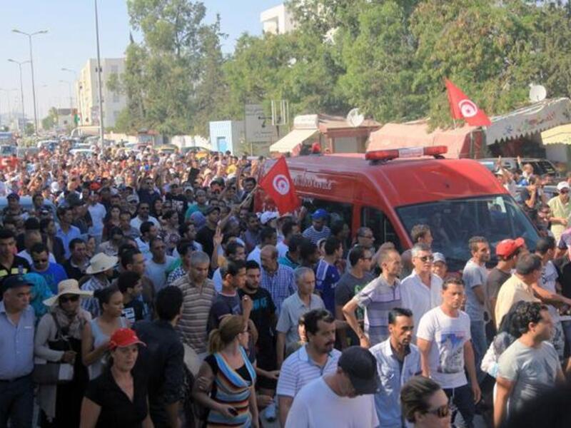 TUNISIA, Tunis : An ambulance, carrying the body of Tunisian opposition politician Mohamed Brahmi, drives to the Charles Nicile Hospital in Tunis before an autopsy after Brahmi was gunned down in front of his home on July 25, 2013. AFP PHOTO / FETHI BELAID