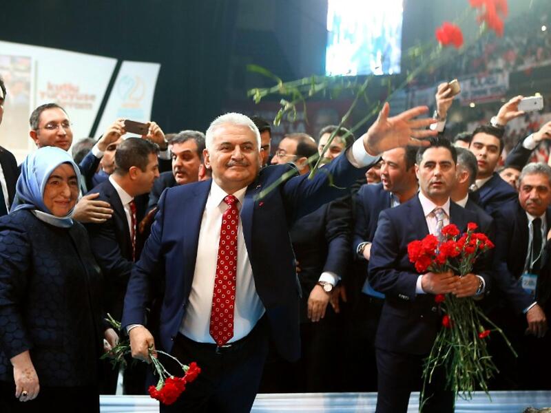 Turkey's Minister of Transport, Maritime and Communication and new chairman candidate for ruling AK Party Binali Yildirim throws red carnations to supporters as he arrives for the second extraordinary congress in Ankara, on May 22, 2016. (AFP/Adem Altan)