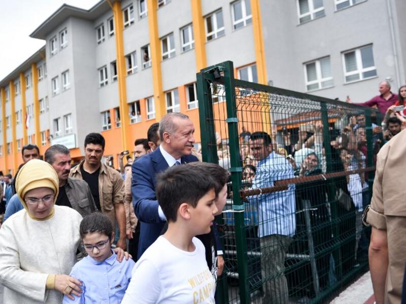 Turkey's President Recep Tayyip Erdogan, leader of the Justice and Development Party (AKP), his wife Emine and their grandchildren are greeted by supporters as they leave the polling station after casting their votes during snap twin Turkish presidential and parliamentary elections in Istanbul on June 24, 2018. (Bulent Kilic / AFP)