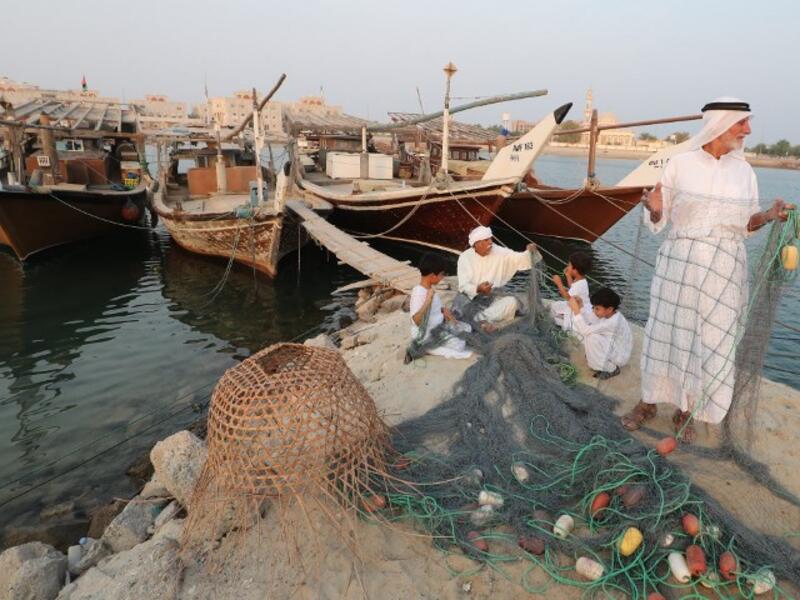 Emirati men train children on handicraft industries during the Dalma Sailing Festival. (KARIM SAHIB / AFP)