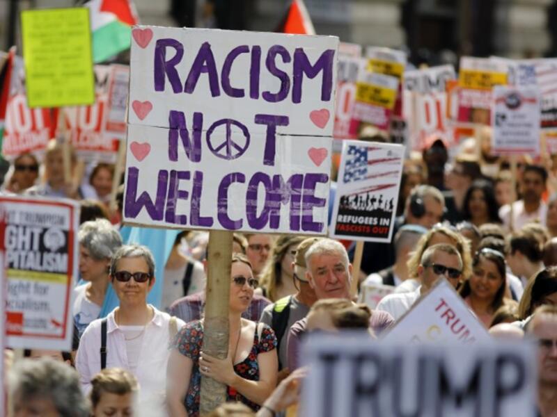 Protesters against the UK visit of US President Donald Trump holding up placards as they take part in a march and rally in London on July 13, 2018.  (Tolga AKMEN / AFP)