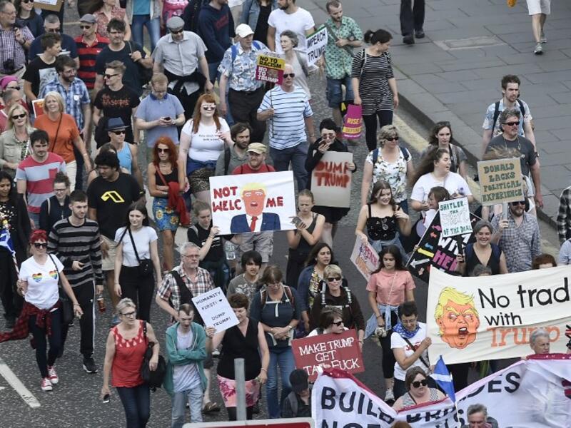 Protestors carry placards as they take part in the Scotland United Against Trump demonstration through the streets of Edinburgh, Scotland on July 14, 2018, on the third day of US President Donald Trump's four-day UK visit. (NEIL HANNA / AFP)