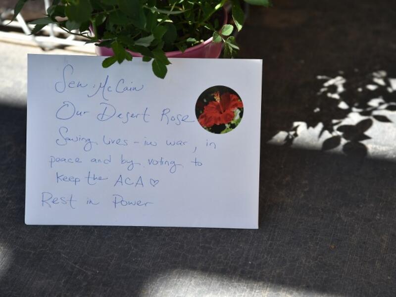 A handwritten note is seen at a makeshift memorial remembering Senator John McCain outside McCain's office in Phoenix, Arizona, August 27, 2018. (Robyn Beck / AFP)