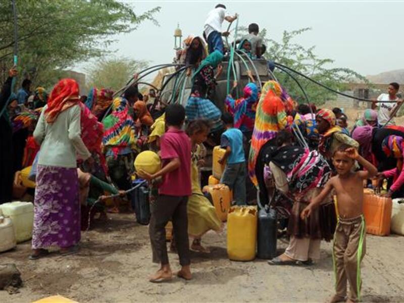 Yemenis gather next to a water tank to collect water in an impoverished coastal village on the outskirts of the Yemeni port city of Hudaydah, on May 12, 2018. (AFP Photo)

