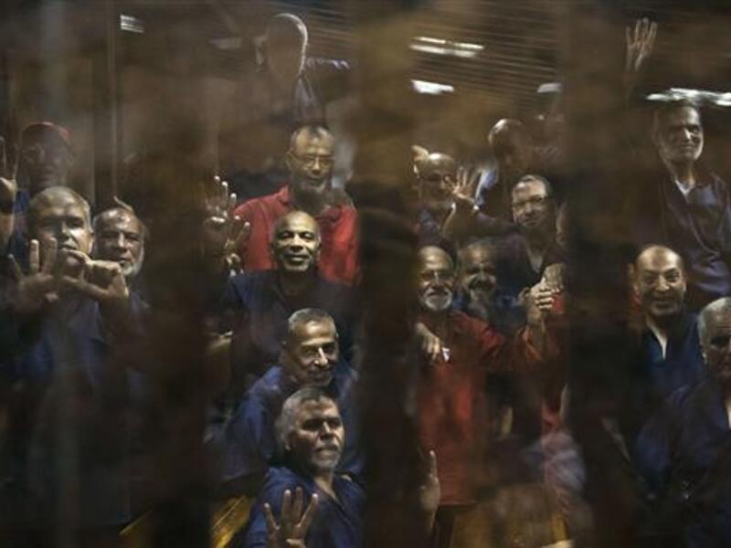 Egyptian Muslim Brotherhood defendants stand behind the bars during their trial. (AFP/File)