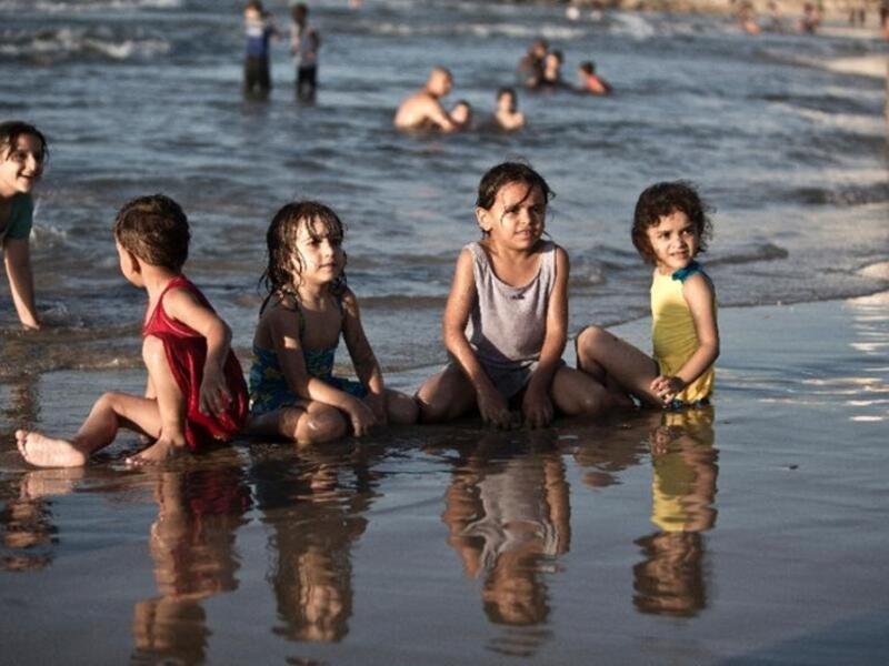 Children play in the water in Gaza City (AFP/File Photo)