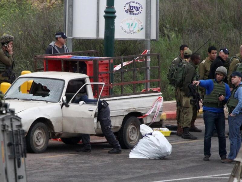 Israeli security forces stand guard at the scene where three Palestinians carried out two attacks -- a shooting and a car ramming -- on Israelis at the entrance of the Israeli settlement of Kiryat Arba near Hebron on March 14, 2016. (AFP/Hazem Bader)