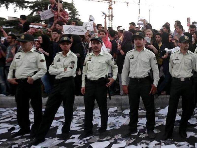 Iranian policemen stand guard as supporters of Iranian moderate presidential candidate, Hassan Rowhani, attend a street rally at Vanak square in northern Tehran on June 12 (Behrouz Mehri / AFP)