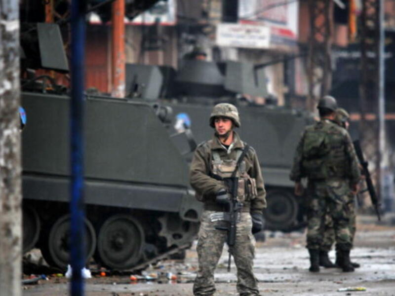 Lebanese army soldiers patrol a street in the northern Lebanese city of Tripoli on December 4, 2013 as the army deployed following clashes between supporters and opponents of Syria's regime. [Ibrahim Chalhoub/AFP]