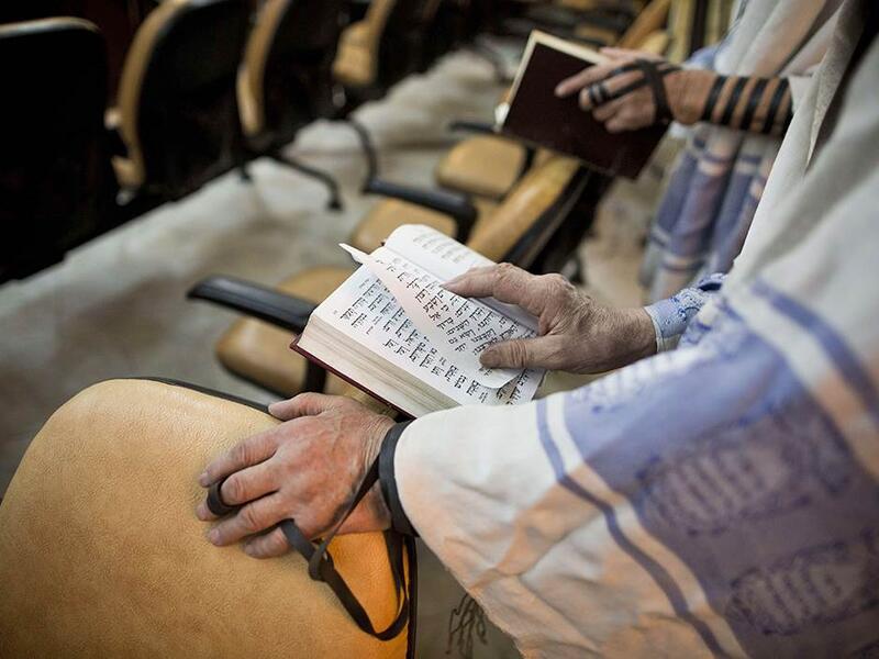 Iranian Jewish men, reading from the Torah, pray at a synagogue in Tehran on September 30, 2013.  (AFP/Behrouz Mehri)