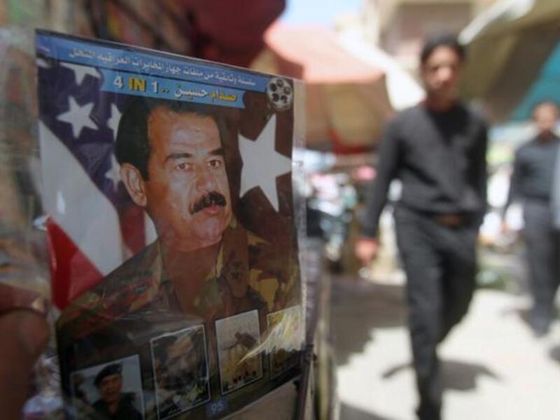 A man holds a CD with a photo of former Iraq President Saddam Hussein (AFP/Ahmad Al Rubaye)