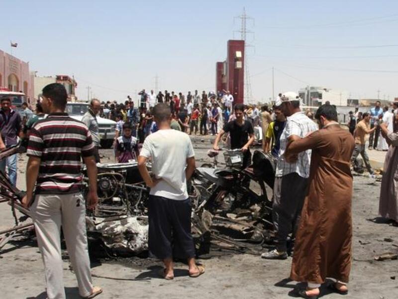 Iraqis inspect the site of a suicide car bomb attack in the Al-Haq square in Samarra, a predominantly Sunni town north of Baghdad, on July 5 (AFP)