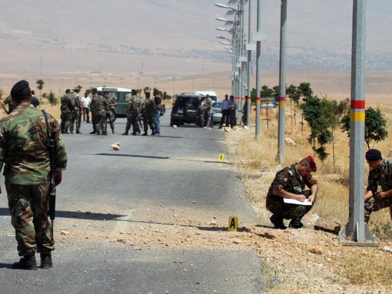 Lebanese army soldiers inspect the site of twin roadside bombs, detonated minutes apart, in the town of Hermel, a few kilometres from Baalbek in the Bekaa valley (AFP)