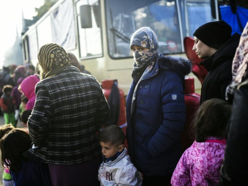 Refugees line up next to a bus in the Idomeni refugee camp. (AFP/File)