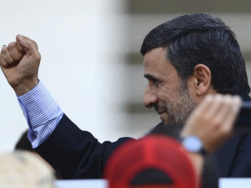Iran's President Mahmoud Ahmadinejad raises his clenched fist in salutation during the funeral of Venezuela's President Hugo Chavez in Caracas. (AFP PHOTO/JUAN BARRETO)