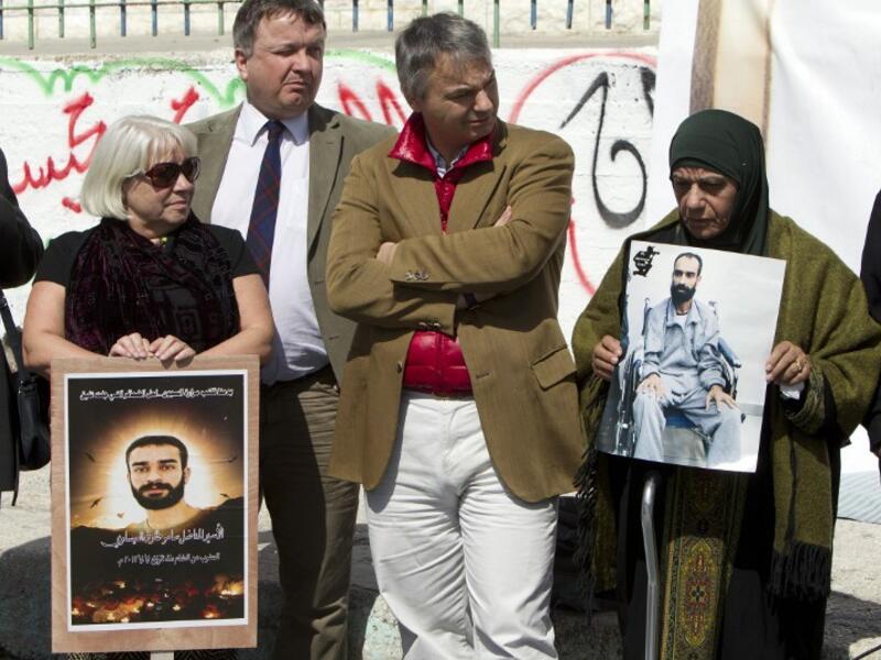 Layla Issawi (R) holds a picture of her son Samer Issawi, a Palestinian held in Israeli jail and on hunger strike for more than 200 days. (AFP PHOTO/AHMAD GHARABLI)
