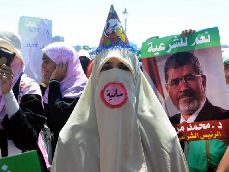 A supporter of Egypt's deposed president Mohamed Morsi, wearing a pin which reads in Arabic "Peaceful", attends a demonstration in the Mediterranean city of Alexandria on August 3, 2013. (AFP)