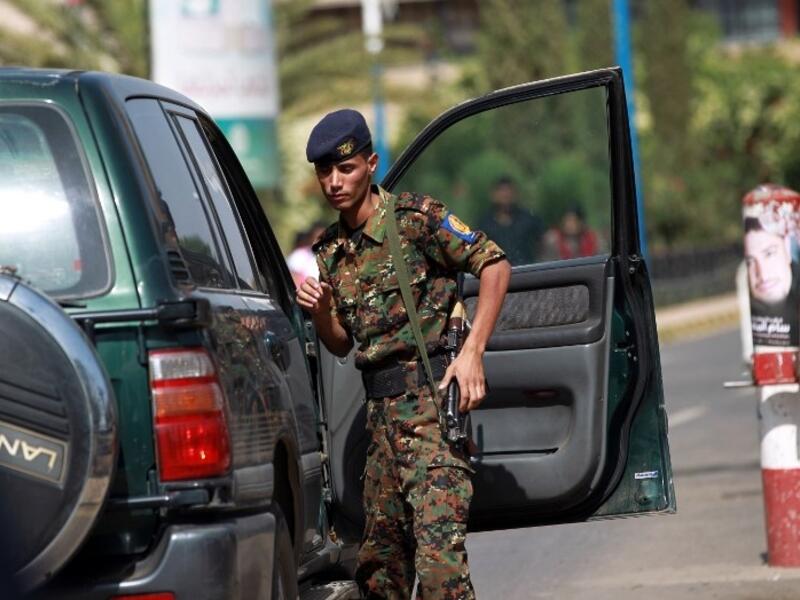 A police trooper inspects a vehicle at the entrance of the Sanaa International Airport on August 7, 2013. (AFP)